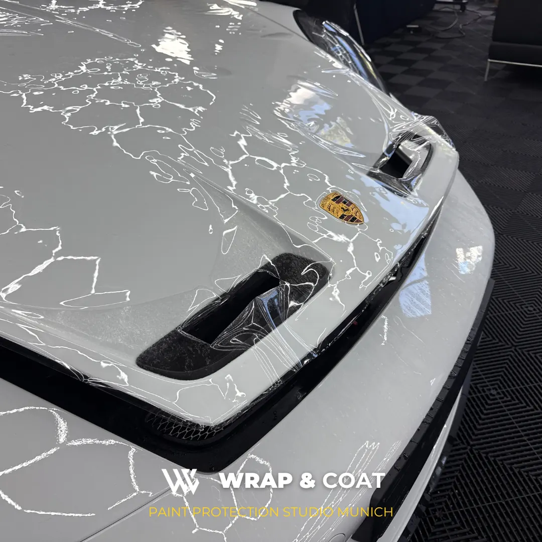 Transparente Lackschutzfolie auf der Motorhaube eines weißen Porsche